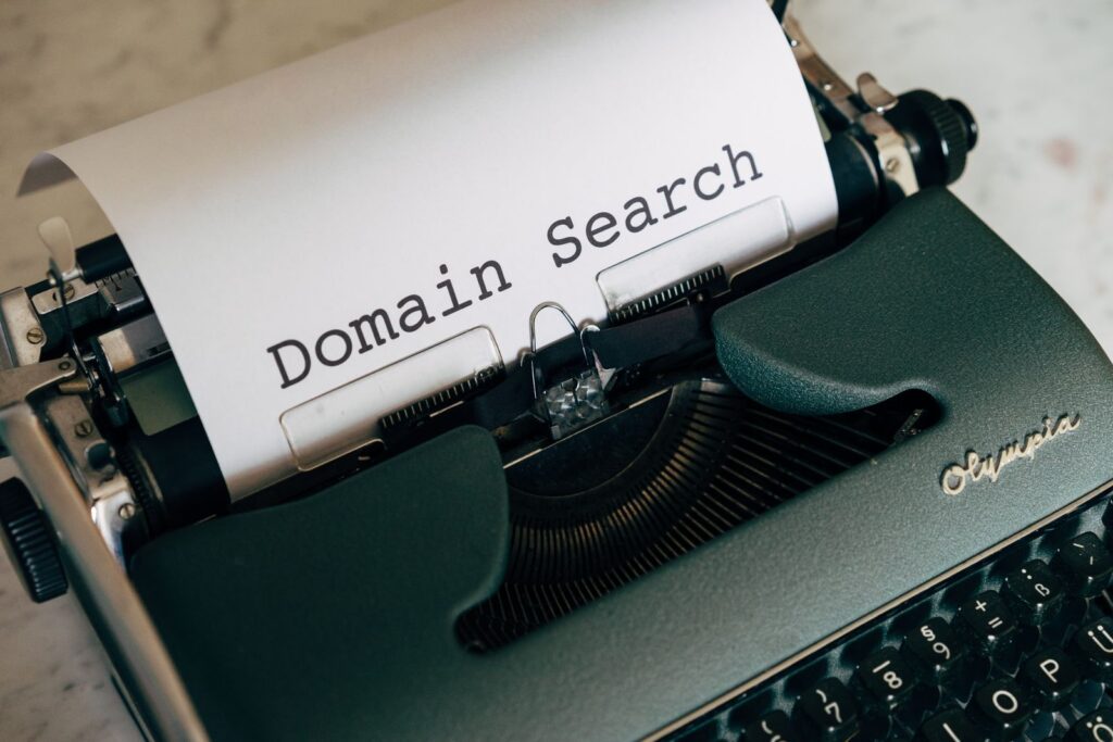 Пишеща машина с лист, на който пише „Domain Search“ — търсене на домейн